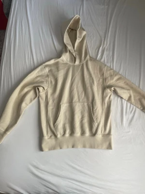 Beige hoodie från Levi's med brodyr - Snygg beige hoodie från Levi's med broderad logga på bröstet. Klassisk känguruficka framtill och huva. Mjuk bomullskänsla och avslappnad passform, perfekt för en chill look.