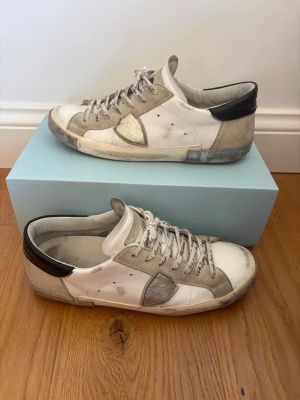 Philippe Model vita sneakers med beige detaljer - Tjena 🙌 jag säljer dessa fetta Philippe modell. De är självklart äkta, box och dustbag ingår‼️ända defekten är att hälarna är lite nedslita de bild 5, men det är inget håll bara nedslitet. 