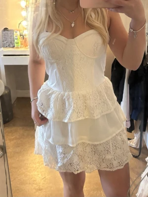 Vit spetsklänning med volanger/ studentklänning  - Söt vit kortklänning med spetsdetaljer och volanger. Knyte vid halsen, står 38 men passar mig som har s