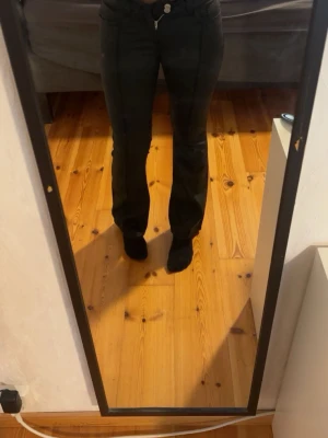 Svarta bootcut läderbyxor från Nelly - Svarta bootcut byxor i lädermönster från Nelly. Byxorna har låg midja och är i storleken 38. Inte använd då de är för korta och små i midjan på mig!