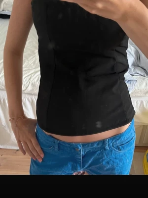 Svart jättesnygg topp - Snygg svart axelbandslös tubtopp med enkel och stilren design. Toppen har en tight passform och är perfekt att matcha med jeans eller kjol. Toppen är aldrig använd och därför i superbra skick! Skriv ifall fler frågor🩷🩷🩷