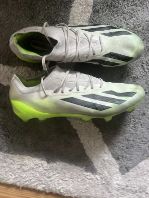 Adidas fotbollsskor crazy fast Elite - Säljer ett par snygga vita Adidas fotbollsskor med svarta ränder och neonfärgade detaljer på hälen. Skorna har låg profil, snörning och är tillverkade i ett lätt syntetmaterial som ger bra bollkontroll och grepp på planen. Elite. Ny pris ca 2500kr