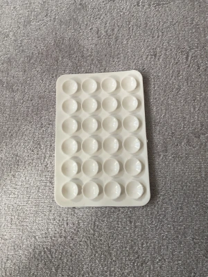 Självhäftande kortficka till mobilskal - Praktisk självhäftande kortficka i beige och vitt som enkelt fästs på baksidan av ditt mobilskal. Perfekt för att förvara kort eller ID. Tillverkad i flexibel plast med 3M-tejp för stark vidhäftning.