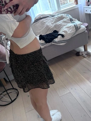 Svart kort volangkjol - En kort volang kjol med rosa och vita prickar 💕💕