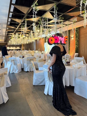 Svart glittrig långklänning - Säljer en otroligt vacker och elegant aftonklänning som passar perfekt för bröllop, bal, fest eller andra speciella tillfällen. Klänningen är i klassisk svart färg med diskreta glittriga detaljer som ger en lyxig och sofistikerad look. Den har en figurnära modell som framhäver silhuetten och en elegant öppen rygg med justerbar snörning, vilket gör att du kan anpassa passformen precis som du vill. Tack vare detta passar den som en universell storlek.