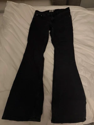 Svarta bootcut jeans från lager 157  - Säljer ett par svarta bootcut jeans från lager 157  med klassisk femficksmodell och utsvängda ben. Jeansen är low boot  och är tillverkade i ett stretchigt denimtyg som sitter snyggt. Perfekta för dig som gillar retrovibbar och vill ha en cool siluett.