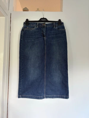Blå jeanskjol midi - Snygg blå jeanskjol . Rak midi-modell med fickor fram och bak. En diskret slits bak. Köpt via Sellpy  från märket Boden. Se bild för storlek, midjemåttet är 76. Mycket bra skick!🤗