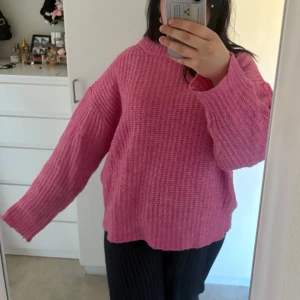 Rosa stickad tröja med lös passform - Mysig rosa stickad tröja med rund hals och lång ärm. Tröjan har en avslappnad, loose passform och är perfekt för lager-på-lager. Enkel design som passar till många olika outfits.