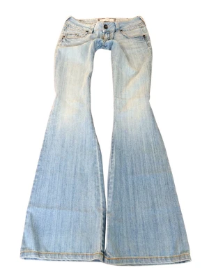 Ljusblå vintage superlågmidjade jeans - Så sjukt snygga bootcut vintage superlågmidjade ljusblå jeans! Midjemått: 40 cm Innebenslängd: 91 cm 