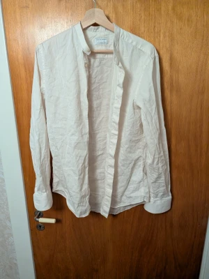 Vit skjorta från Tiger of Sweden - Stilren vit skjorta från Tiger of Sweden i slim fit-modell. Skjortan har klassisk krage och långa ärmar, tillverkad i mjuk bomull. Perfekt för dig som gillar en clean och enkel look.