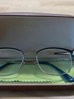 Longchamp - Longchamp eyeglasses frames in silver and blue. Includes original Longchamp case. Very good condition, no visible damage. Lightweight and elegant design. Ready for new prescription lenses. From smoke-free home. Can ship same or next day.