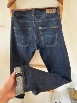 Selvedge Nudie Jeans - W31/L34 dry selvedge nudie jeans. Modellen är Grim Tim och i helt nytt skick. 
