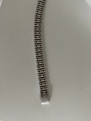  BOSS armband - Snyggt länkarmband till klocka från BOSS i silverfärgad metall. Klassisk design med rektangulära länkar och diskret BOSS-logga på spännet. Perfekt för dig som vill uppgradera din klocka med en stilren och tidlös look. Rostfrittstål med silver och guld färgade detaljer.