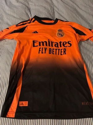 Real Madrid Bellingham matchtröja  - Snygg Real Madrid matchtröja i orange och svart med Bellingham och nummer 5 på ryggen. 