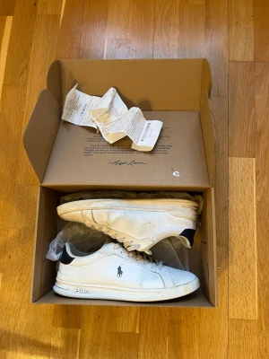 Vita Polo Ralph Lauren sneakers - Ett par feta sneakers från Polo Ralph Lauren i bra skick, har lite defekter som är synliga på bild,  Allt OG ingår! Även kvitto! Storlek - 42  Pris - 599kr Tveka inte vid frågor eller funderingar! (Priset kan diskuteras)