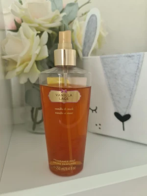 Vanilla Lace body mist från Victoria's Secret - Vanilla Lace body mist från Victoria's Secret med doft av vanilj och mysk. Flaskan är genomskinlig med guldigt spraymunstycke och rymmer 250 ml. Perfekt för dig som gillar söta och mjuka dofter.                 Säljer nu av min vintage kollektion. Perfekt för samlare. Eftersom dofterna är vintage kan lukten skilja sig markant från nya, och köps därmed på eget bevåg.
