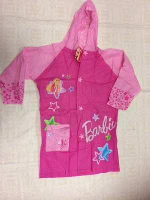 Rosa Barbie regnjacka med huva - Snygg rosa regnjacka från Barbie med huva och tryckta stjärnor på ärmarna. Jackan har stora Barbie-tryck både fram och bak samt en praktisk ficka framtill. Tillverkad i vattenavvisande material, perfekt för regniga dagar. Stängs med tryckknappar. Stlk 120-130