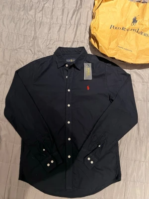  Polo Ralph Lauren skjorta - Säljer en polo Ralph Lauren skjorta som jag fick för en månad sen men passade inte mig , jag klippte av lappen för jag tänkte att jag skulle andvända den men blev ej så, den är aldrig andvänd och nypris är 1600kr pris kan diskuteras vid snabb affär!😄