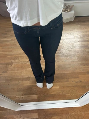Mörkblå bootcut jeans - Säljer ett par Levi's 527 bootcut jeans i mörkblå tvätt som jag sytt om till en ännu mer lågmidjad passform 💕skriv för fler bilder!😊(innebenslängd är 81cm och midjemåttet är 80cm) 