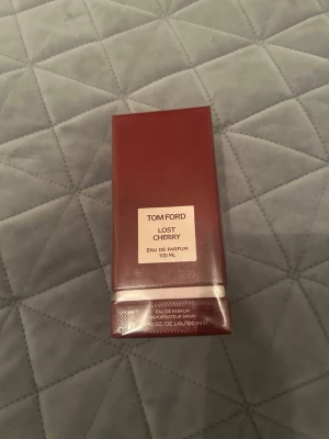 Tom Ford Lost Cherry EdP 100 ml - Tom Ford Lost Cherry Eau de Parfum 100 ml i en elegant mörkröd rektangulär flaska med stilren etikett. Doften är känd för sina söta och fruktiga körsbärstoner och exklusiva känsla. Perfekt för dig som vill sticka ut med en unik och lyxig parfym. Helt ny 