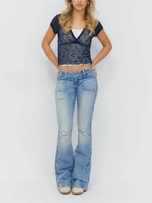 Ljusblå bootcut jeans med slitningar - Säljer ett par ljusblå bootcut jeans med slitningar på låren och knäna. Jeansen har låg midja, klassiska fem fickor och en tvättad look som ger en avslappnad vibe. Perfekta för dig som gillar retrostil och vill ha ett par jeans som sticker ut.