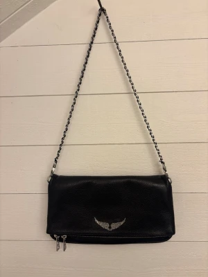 Svart axelväska Zadig & Voltaire - Snygg svart axelväska i läder från Zadig & Voltaire med silverfärgad kedja. Väskan har dubbla dragkedjor och en stilren, avlång form!