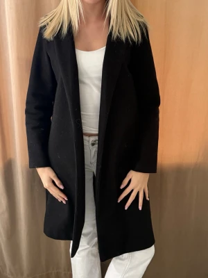 Svart klassisk kappa - Stilren svart kappa med rak passform och enkel design. Köpt på plick, saknar tyvärr knytet🥹 Super fin!!! 