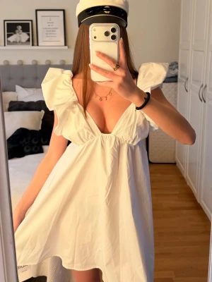 Studentklänning - Supersöt vit kortklänning med volangdetaljer på axlarna och djup v-ringning. Passar både xs och s skulle jag säga, köpte via Plick och den har inget märke. Pris går att diskutera! 