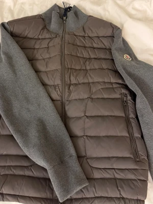 Moncler Cardigan - Säljer en helt ny Moncler cardigan i storlek L (bärs mer som S/M). Inga fel på cardiganen. Skicka ett meddelande om du vill ha mått på jackan!