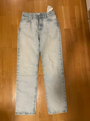 Ljusblå raka jeans från Zara  - Säljer ett par ljusblå jeans med rak passform och klassisk femficksdesign. Jeansen har hög midja och är tillverkade i ett robust denimtyg. Perfekta för en avslappnad och trendig look.