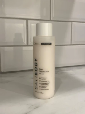 Bali Body Self Tanning Milk - Bali Body Self Tanning Milk i nyansen medium-dark. Flaskan är vit med svart text och innehåller 240 ml. Produkten är en brun utan sol-mjölk med naturliga ingredienser  och återfuktande egenskaper. Perfekt för dig som vill ha en solkysst look året runt.