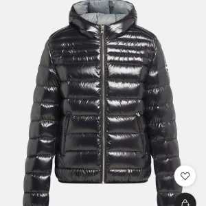 Svart pufferjacka från Colmar - Snygg svart pufferjacka från Colmar med glansig finish och klassisk logga på ärmen. Jackan är ny från förra året det vill säga ändats använd en vinter. Det står att den är i storlek 40 vilket inte stämmer skulle säga en XS ordinarie pris 5000kr 