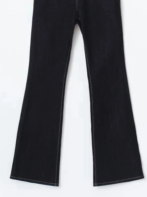 Svarta bootcut jeans med vit söm - Snygga svarta bootcut jeans med kontrasterande vita sömmar. Jeansen har en klassisk femficksmodell och är tillverkade i ett stadigt denimtyg. Perfekta för dig som gillar en tidlös men trendig look. Använda endast 1 gång och säljer då dem är lite långa för mig. 