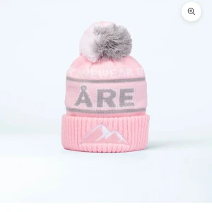 Rosa åre mössa - Säljer en rosa mössa från onewear med grå och vit text samt en stor grå tofs på toppen. Andvänd två gånger. Skriv för pris!🩷