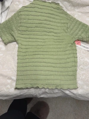 Grön ribbad topp från  Stories - Säljer en ljusgrön ribbad topp.