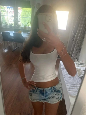 Ljusblå lowwaist jeansshorts  - Snygga low waist jeansshorts med svart text i strl 36, midja 39cm. Se min profil för liknande plagg!