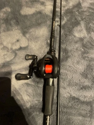 Baitcasting spö med rulle och lina - Säljer ett svart baitcasting fiskespö med matchande rulle och röd fiskelina. Handtaget är i mjukt gummimaterial för bra grepp och spöet har en kolfiberlook. Perfekt för dig som gillar sportfiske och vill ha kontroll på kastet. Jag har haft de i en vecka och har fiskat med de kanske 3 gånger men inte riktigt min typ med spö men riktigt skönt och fiska me. Hör av dig om du har frågor! Kostar 1500 nytt utan Lina