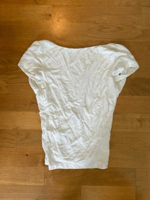 Vit Topp Gina Tricot - Vit topp med djup rygg. Inköpt på Gina Tricot. Använd några gånger men i fint skick. Storlek XS. 