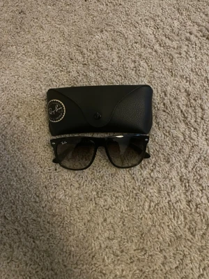 Svarta Ray-Ban boyfriends - Klassiska svarta boyfriend solglasögon från Ray-Ban med ikonisk form och Ray-Ban-logga på bågen och glaset. Snygg och tidlös design som passar till allt. Bågarna är i plast och glasen är mörka.