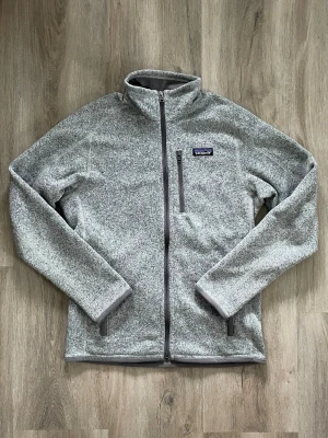 Patagonia fleece - Till salu är en Patagonia Better Sweater fleece i storlek S i gott skick. Snygg grå färg, varm och bekväm att bära. Perfekt för vardagsbruk, utomhusaktiviteter och lager-på-lager-kläder. Skick: Gott begagnat skick. Observera: Det finns en fläck på vänster ärm, vilket syns på bilderna. Annars är fleecetröjan i gott skick. Säljer den eftersom den är för liten för mig.