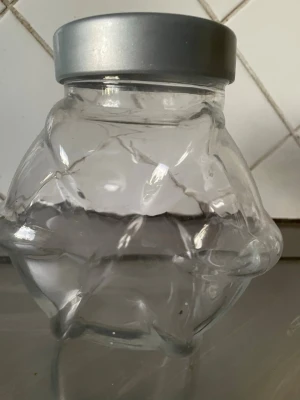 Glasburk med silverlock - Unik glasburk med spännande, oregelbunden form och ett stilrent silverfärgat skruvlock. Perfekt för förvaring av småsaker, godis eller dekoration. Tillverkad i klart glas som gör innehållet synligt och ger en modern känsla till rummet.
