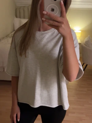 Ljusgrå oversized t-shirt - Säljer en ljusgrå oversized t-shirt med rund hals och korta ärmar. T-shirten har en avslappnad passform och är tillverkad i mjuk bomull, perfekt för en chill och enkel stil.