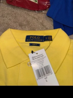 Gul pikétröja från Polo Ralph Lauren - Snygg gul pikétröja från Polo Ralph Lauren i slim fit-modell. Klassisk krage och knappar framtill. Perfekt för dig som gillar stilrena och färgglada plagg. Tillverkad i mjuk bomull som känns skön mot huden.