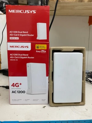 Mercusys AC1200 4G+ Gigabit Router - Säljer en vit Mercusys AC1200 Dual Band 4G+ Cat 6 Gigabit Router, modell MB230-4G. Routern har en stilren, rektangulär design i plast och stödjer både 2.4GHz och 5GHz WiFi. Utrustad med två LAN-portar och plats för SIM-kort för mobilt bredband.