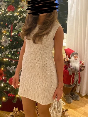  Pärlklänning från Zara - Krämvit stickad ärmlös klänning från Zara med pärldetaljer. Klänningen har rak passform, rund halsringning och grovstickat material som ger en mysig känsla. Perfekt för vinterns alla tillfällen.