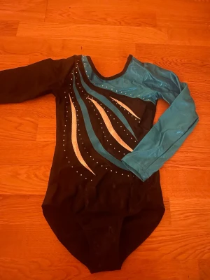 Svart och turkos gymnastikdräkt - Säljer min gamla gymnastikdräkt, använd typ 2 gng💕skulle nog säga att den passar barn 6-9 år 🤗