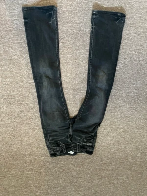 Svarta slim jeans från Gina Tricot - Säljer ett par svarta slim fit jeans från Gina Tricot i storlek 158. Jeansen har klassisk femficksdesign, smala ben och snygga slitningar för en trendig look. Tillverkade i mjukt denimtyg med vita kontrastsömmar.