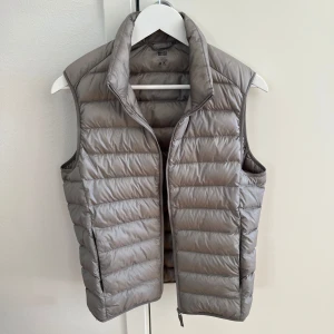 Grå dunväst från Uniqlo - Säljer en stilren ljus grå dunväst från Uniqlo. Nypris 599, mitt pris 449. Lite kort på mig som är 184. Hör av er vid frågor!