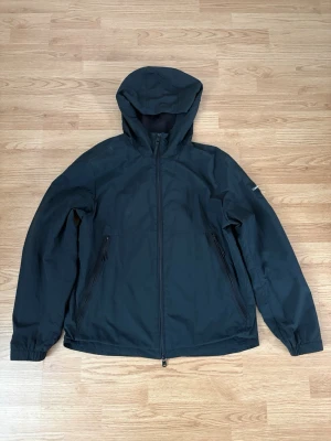 Calvin Klein Vindjacka - Säljer denna då den inte längre används  Märke - Calvin Klein  Storlek - L  Längd - 70cm  Armhåla till armhåla - 56cm Ärmlängd - 47cm  Pris går att diskuteras