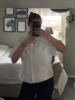Vit skjorta från Zara - Säljer en vit skjorta från Zara i storlek XS. Skjortan har korta ärmar, klassisk krage och knappar framtill. Perfekt för en clean och stilren look. Tillverkad i mjuk bomull som känns skön mot huden.